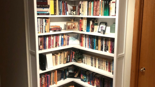 Кутова книжкова полиця з книгами та декором